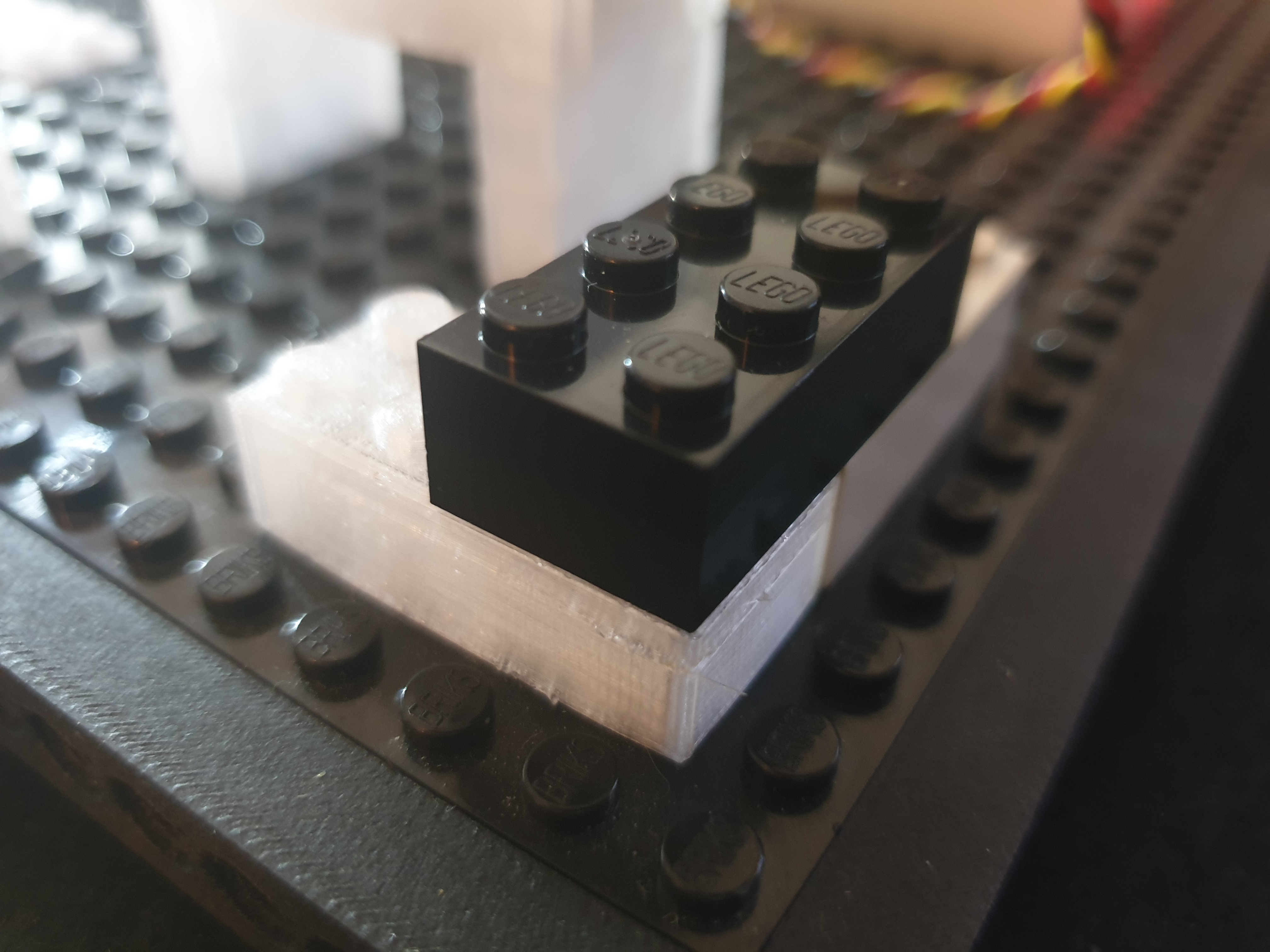 Original LEGO® brick stacked on a 3D printed brick